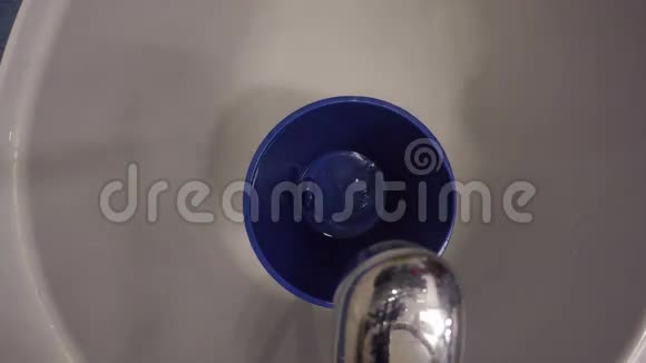 水与泡沫一起流入桶中相机挂在水龙头手柄上4K视频的预览图