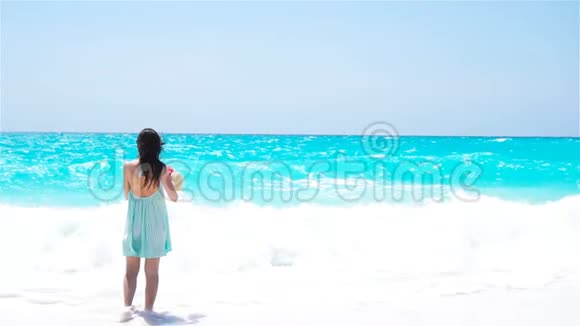 沙滩上穿夏装的女人的后景视频的预览图