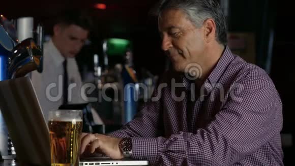 在酒吧喝一品脱的人用笔记本电脑视频的预览图