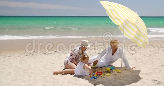 奶奶妈妈和小女孩在沙滩玩视频的预览图