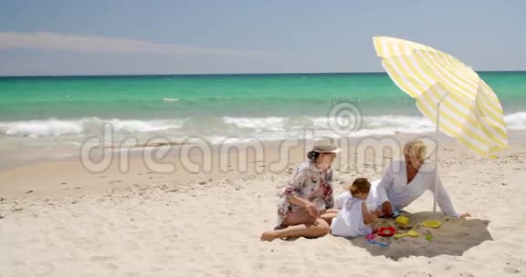 奶奶妈妈和小女孩在沙滩玩视频的预览图
