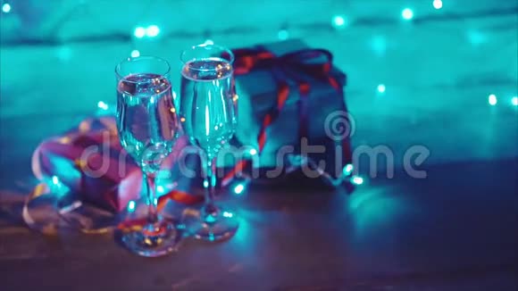 合上圣诞礼物和两杯冒泡的香槟蓝威士忌视频的预览图