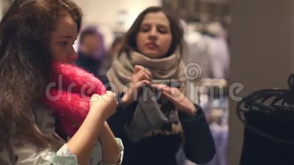 店里有两个年轻的女人在店里挑选温暖的冬装视频的预览图