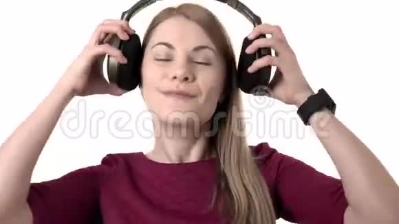 漂亮迷人的女士带着耳机在智能手表上听音乐孤立的白色背景视频的预览图