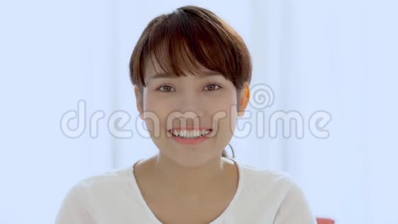 美丽的特写照片年轻的亚洲女人在卧室里笑着视频的预览图
