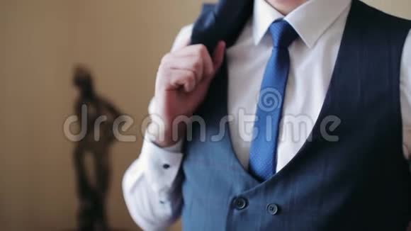 扣上一件夹克穿西装的时髦男人把扣子系在夹克上准备出门关门视频的预览图