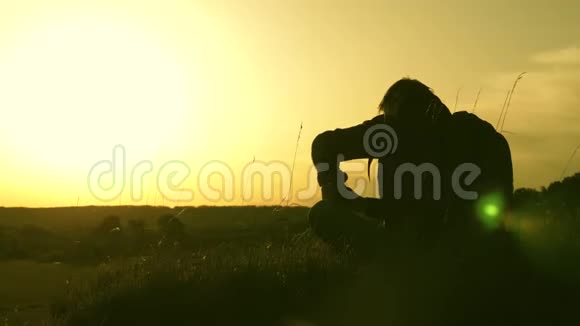 孤独的旅行者坐在山顶上在热水瓶里喝咖啡游客喝热茶看日落休息休息视频的预览图