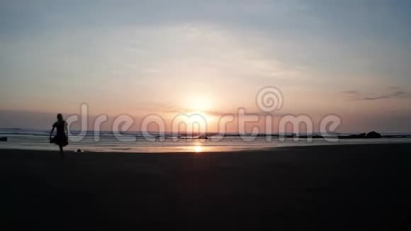 美丽的日落海滩上的女人剪影视频的预览图