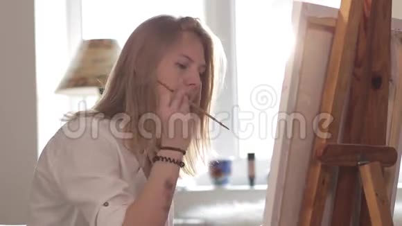 女画家坐在窗边画水彩画视频的预览图