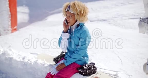 笑的女人在雪地里用手机聊天视频的预览图