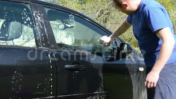 花园院子里的人用海绵洗汽车视频的预览图