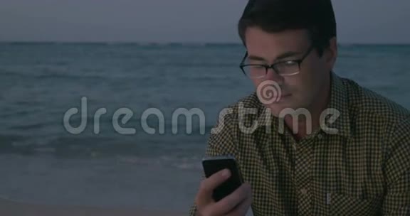 在海边使用智能手机的人视频的预览图