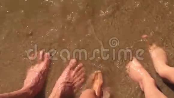 男孩女孩水和男人家庭腿在海洋慢动作视频强浪沙海休息家庭视频的预览图
