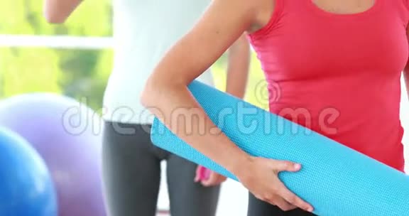微笑运动的女人拿着瑜伽垫视频的预览图