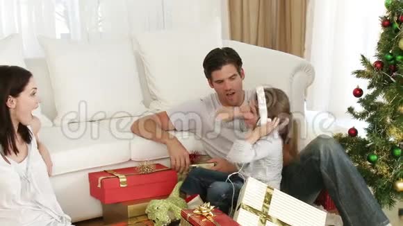 父母和小女孩玩圣诞礼物视频的预览图