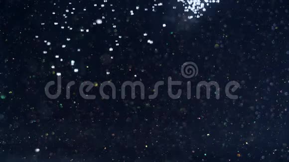 闪闪发亮的黑暗背景突然被无数白色的雪球从上面落下的灯光填满视频的预览图