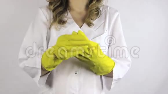 穿白袍的女人把黄色橡胶手套脱手视频的预览图
