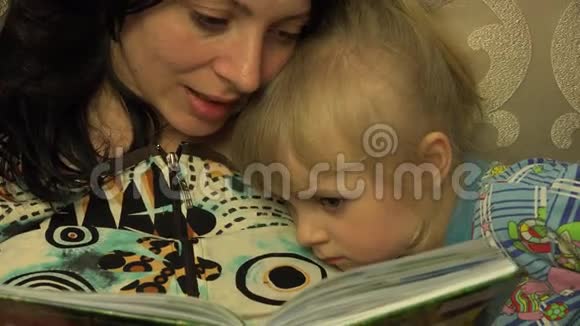 年轻的母亲和她的小女儿一起读书4K超高清超高清视频的预览图