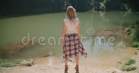 美丽的白种人女孩花时间在树林里的湖边视频的预览图