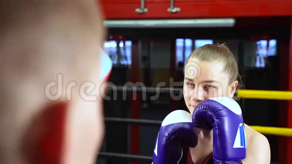 在健身房和拳击教练一起训练女拳击手视频的预览图