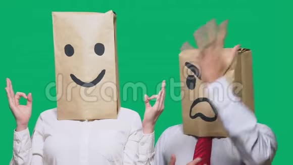 情绪和手势的概念两个人头上装着纸袋上面画着微笑咄咄逼人的微笑视频的预览图