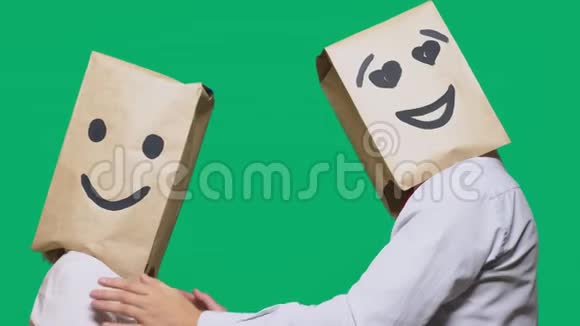 情感的概念手势两个人头上戴着纸袋画着表情符号微笑着快乐着视频的预览图