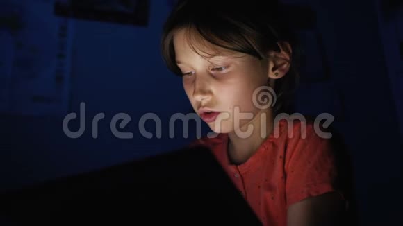 多利在黑暗的蓝光下在网上玩平板电脑在床上射杀了高加索女孩视频的预览图