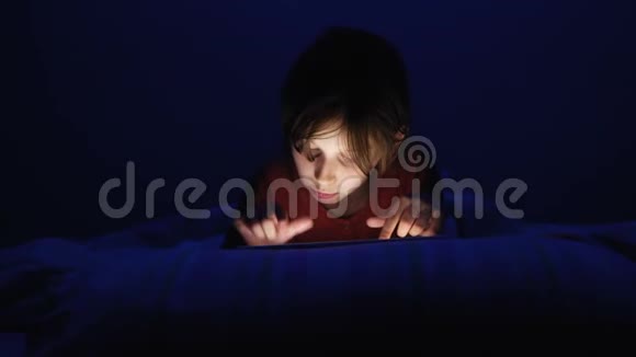 多利在黑暗的蓝光下在网上玩平板电脑在床上射杀了高加索女孩视频的预览图