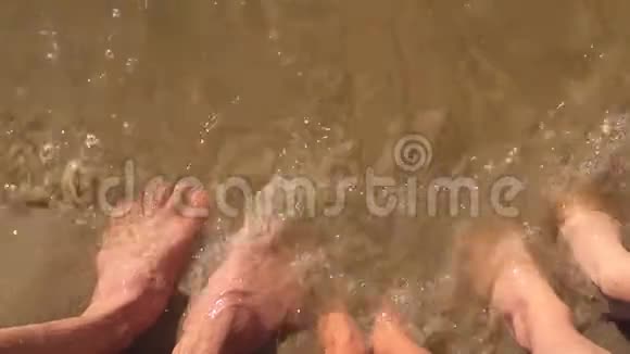 男孩水女孩和男人家庭腿在海洋慢动作视频强浪沙海休息家庭视频的预览图