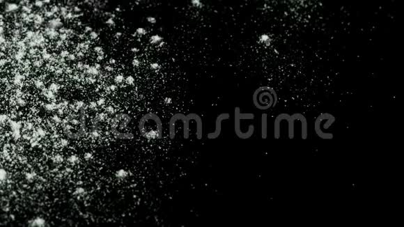 白色粉末在黑色背景上脱落库存录像白色干墨滴在深色表面视频的预览图
