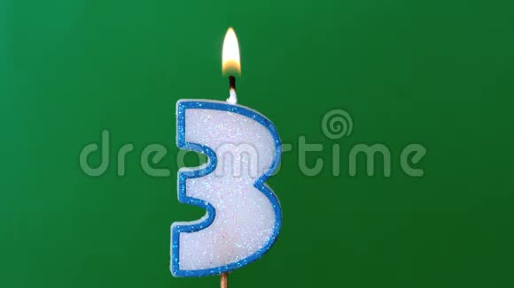 三支生日蜡烛在绿色背景下闪烁熄灭视频的预览图