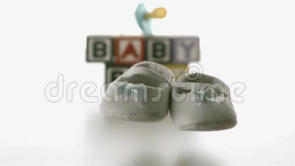 婴儿鞋落在蓝色肥皂和婴儿积木前面视频的预览图