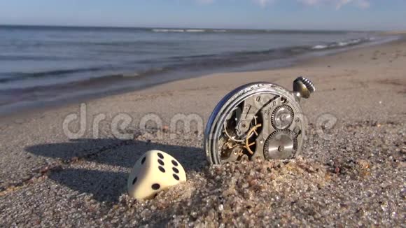 海和幸运时间概念海滩上的骰子和旧钟视频的预览图
