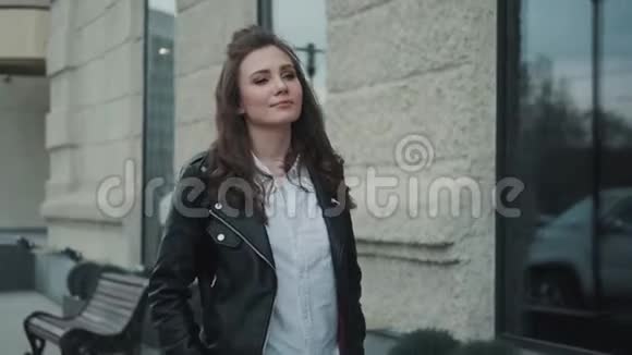 在城里散步的嬉皮士女孩街上一个穿皮夹克的年轻女人的肖像视频的预览图