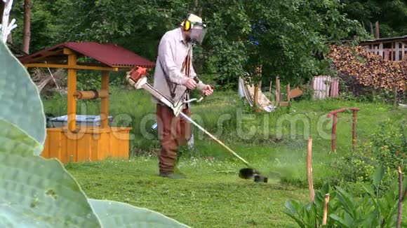 园丁在农村水井房附近割草种树叶视频的预览图