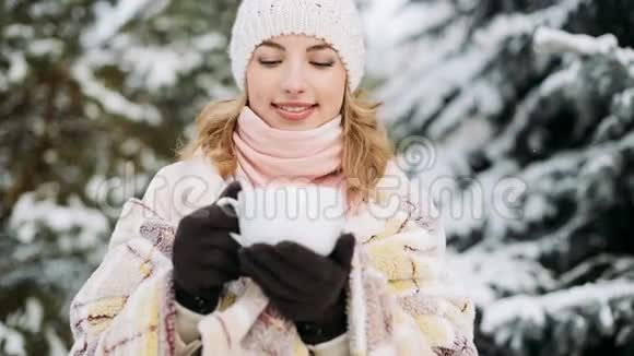 女孩在冬天的森林里户外喝酒视频的预览图