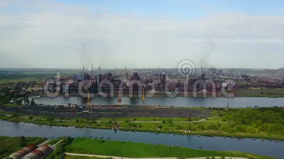 从靠近海洋的冶金厂看到空气大气和河水污染的工业化城市上空视频的预览图