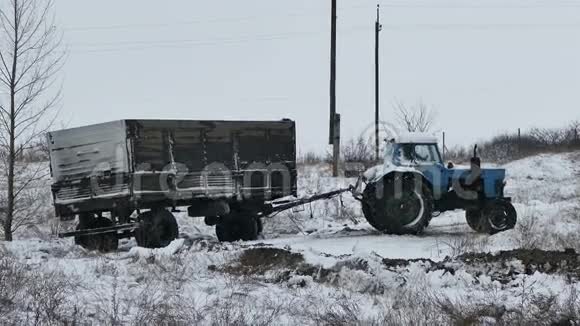 拖拉机拖车在冬天的路上陷在雪里视频的预览图
