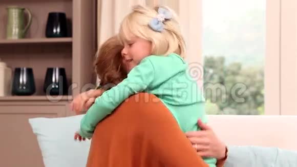 可爱的小女孩在沙发上抱着妈妈视频的预览图