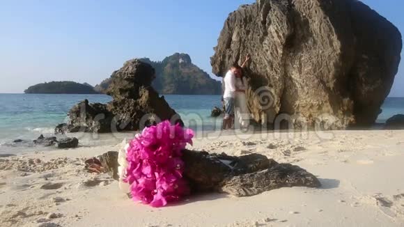 新娘和新郎站在水中花束在前台视频的预览图