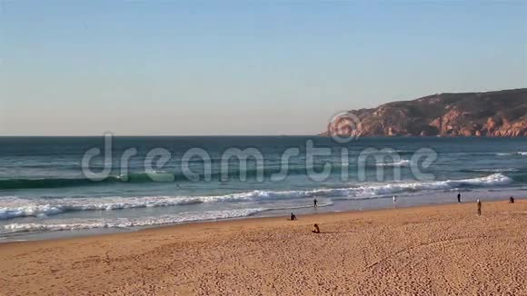 海滩上的人们海浪拍打着向海岸靠近视频的预览图