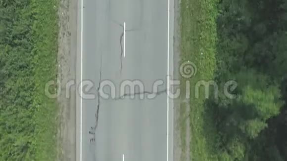 阳光明媚的一天汽车沿着空旷的乡村道路行驶上面的鸟瞰图视频的预览图
