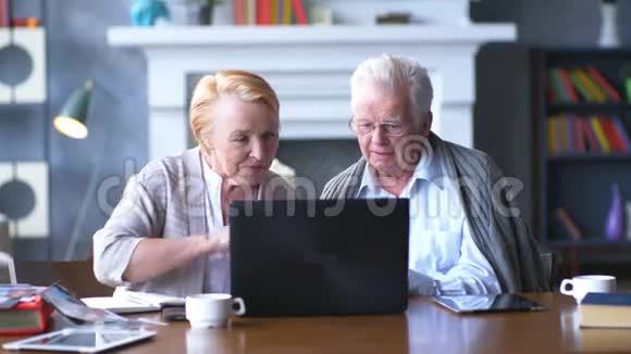 老年夫妇用笔记本电脑上网快乐的老人使用电脑视频的预览图