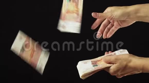 女性手把五千卢布钞票撒在黑色背景慢动作股票录像上视频的预览图