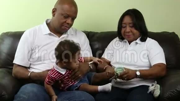 非洲母亲给婴儿腿穿上鞋子视频的预览图