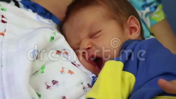 新生儿男孩在母亲怀里打哈欠视频的预览图
