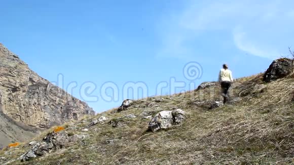 一位年轻女子爬上山举起双臂视频的预览图