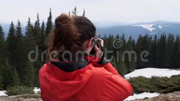 女徒步旅行者在山上拍摄风景视频的预览图