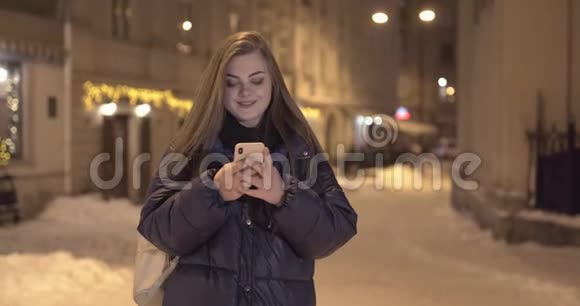 夜城街头散步时使用手机的女人视频的预览图
