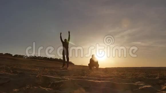 跑步者两个人在沙滩上奔跑太阳落山赛跑者视频的预览图